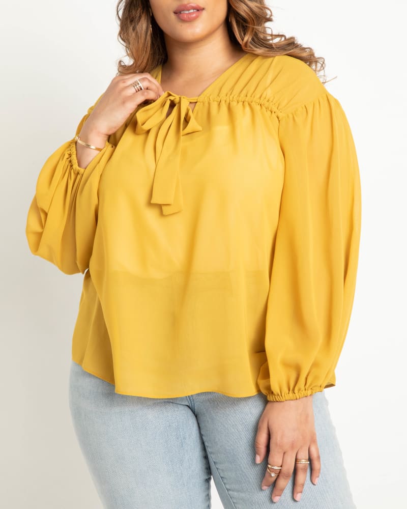 Front of a model wearing a size 20 Tunnel Detail Chiffon Blouse in Bright Gold by ELOQUII. | dia_product_style_image_id:275224